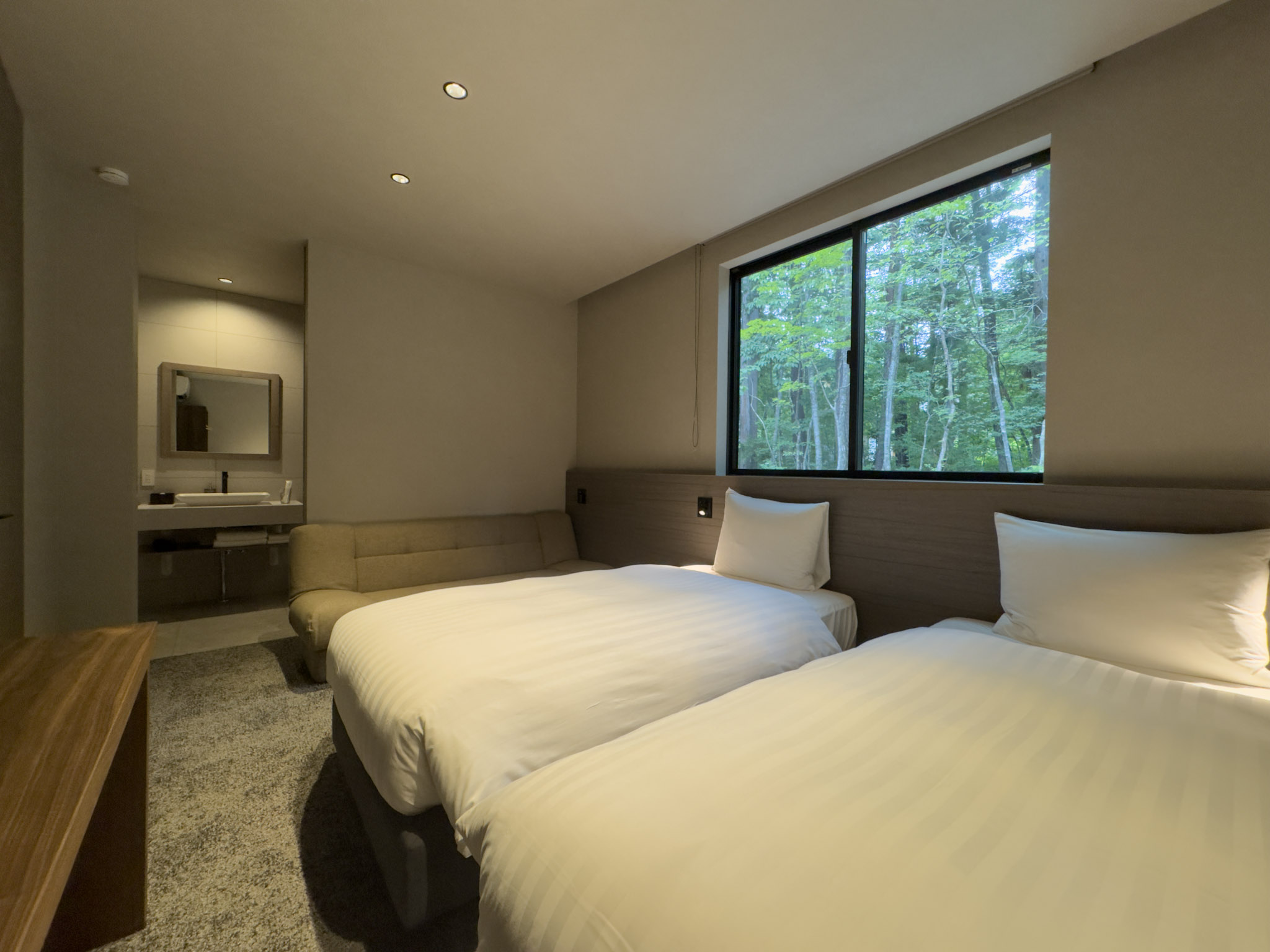Bedroom 2 with two single beds, a sofa bed and forest views