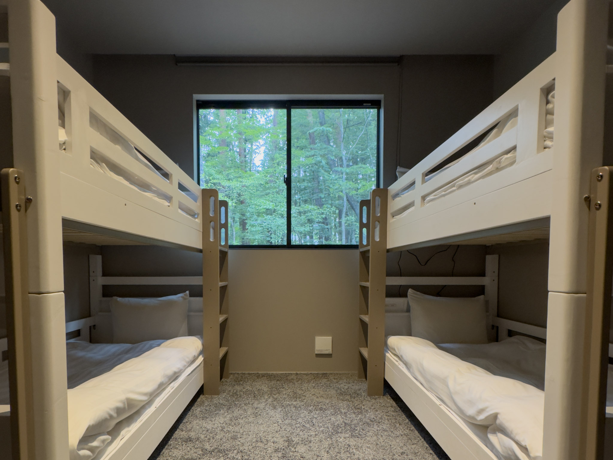 Bedroom 3 with two bunk beds and a window overlooking the forest